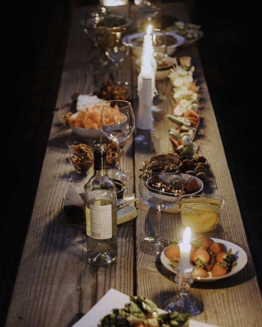 A long wooden table laid with plates of food, seen from above