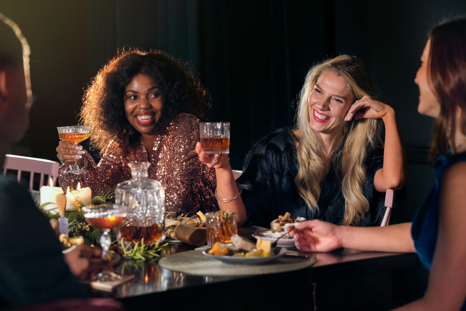 Friends laughing together around a dinner table