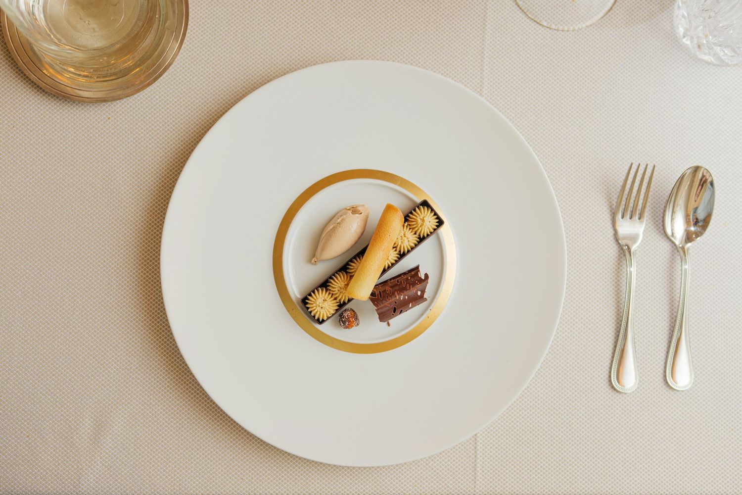 A plated dessert on a white plate with a gold rim